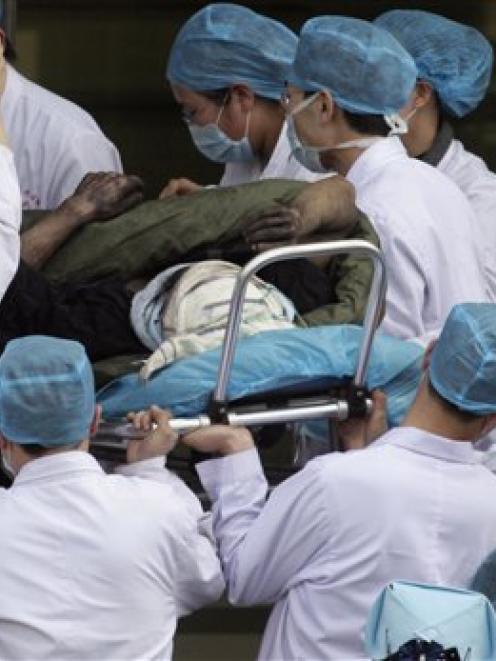 A coal miner rescued from the Wangjialing Coal Mine in Xiangning county is rushed into a hospital...