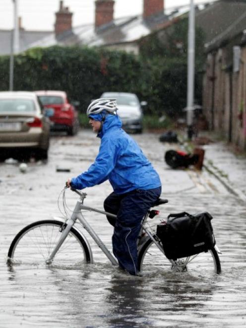 A commuter makes his way to work through flooded streets in Dublin. Photo: REUTERS/Cathal McNaughton