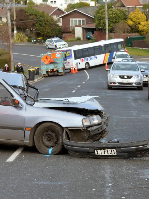 A contractor inspects the scene of a car crash in Highcliff Rd, Dunedin, yesterday. Photo:...