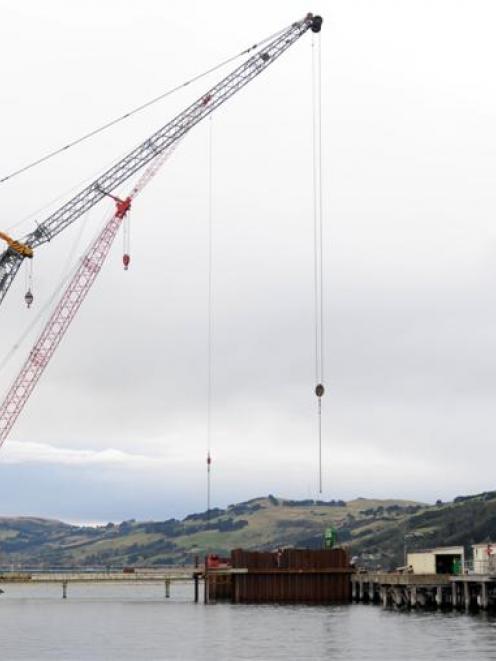 A contractor's crane drives the first sheet piles into the seabed at Port Otago's oil wharf in a...