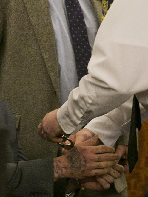 A court officer places handcuffs on the wrists of former NFL player Aaron Hernandez after the...