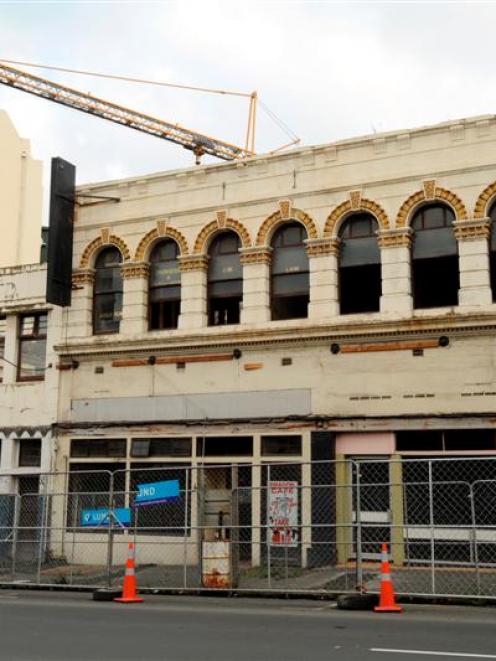 A crane is set to knock down the remainder of the N. & E. S. Paterson and Barrons Buildings...