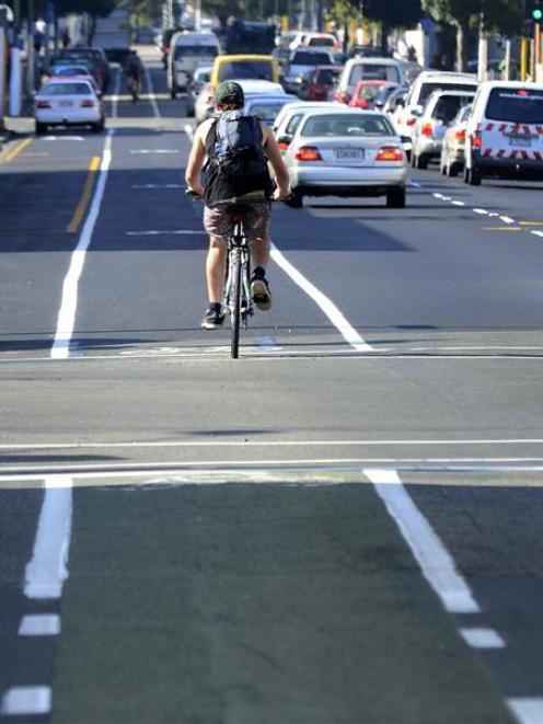 A cyclist heading north on Cumberland St, a Dunedin one-way street, passes St Andrew St and...