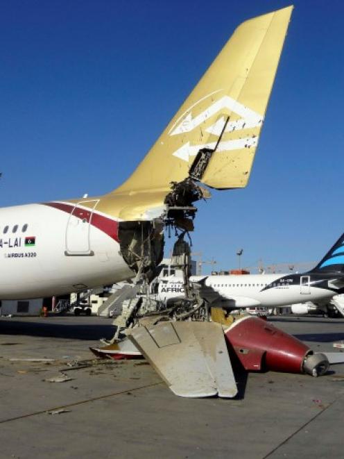 A damaged aircraft sits on the ground after shelling at Tripoli International Airport. REUTERS...