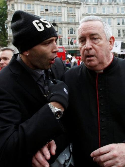 A demonstrator directs questions to the Dean of St Paul's, the Right Reverend Graeme Knowles,...