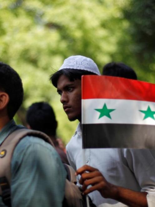 A demonstrator holds the Syrian flag during a protest in New Delhi, India, against potential US...