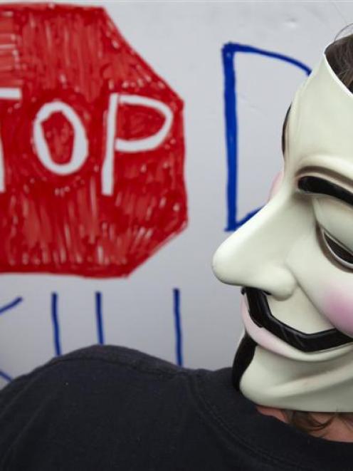 A demonstrator wearing a Guy Fawkes mask  during a street protest near the site of the Democratic...