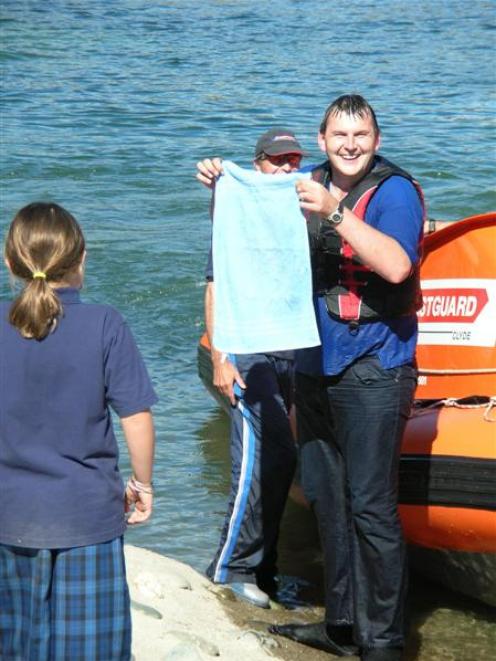 A drenched Dan Murphy accepts a towel from a young girl after jumping into the Clutha River...