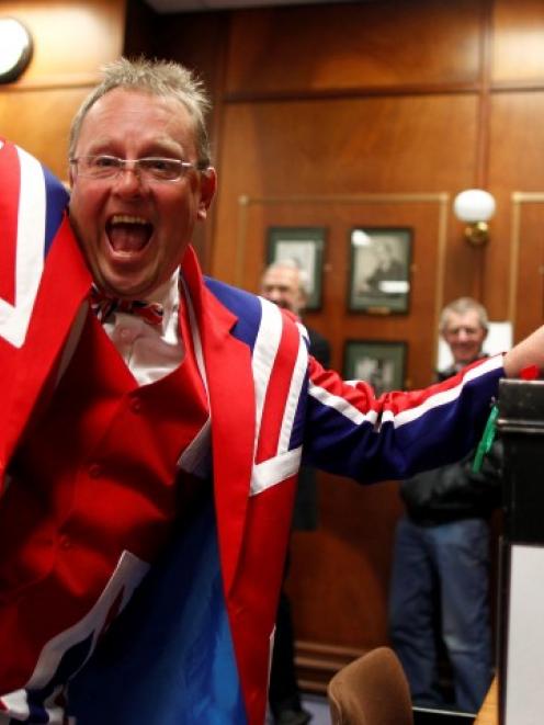 A Falkland Islander gestures as he casts his vote at the Town Hall polling station in Stanley....