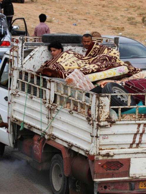 A family fleeing the fighting in Sirte is pictured at a checkpoint 4km outside the city...