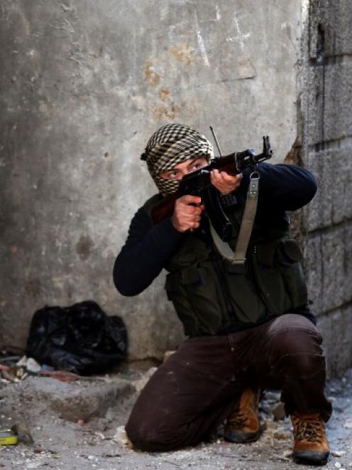 A fighter from the Sadik unit of Free Syrian Army's Tahrir al Sham brigade aims his rifle in...