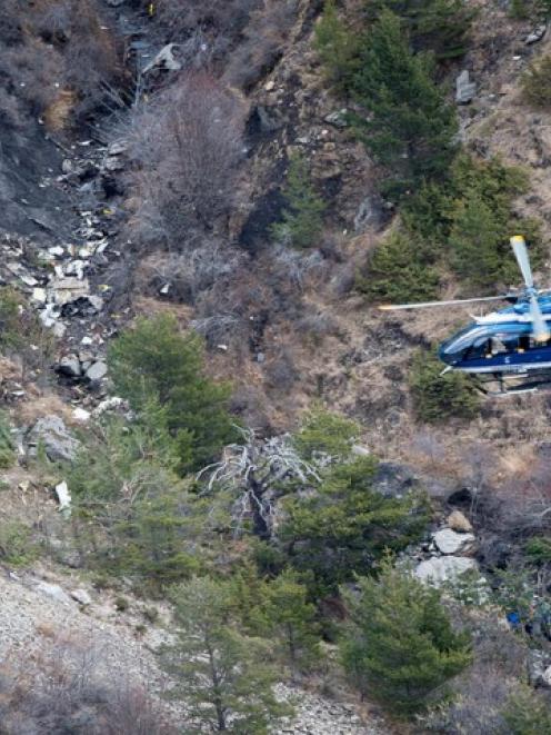 A French gendarme helicopter flies over debris at the crash site near Seyne-les-Alpes. REUTERS...