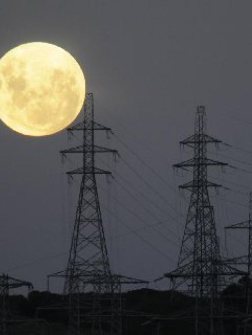 A full moon rises over transmission pylons at Three Mile Hill, near Dunedin. Photo by Stephen...