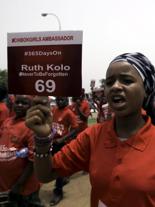 A girl holds a sign during a march to mark the one-year anniversary of the mass kidnapping of...