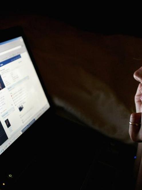 A girl in London looks at a page on Facebook. Studies have shown that many teens using social...