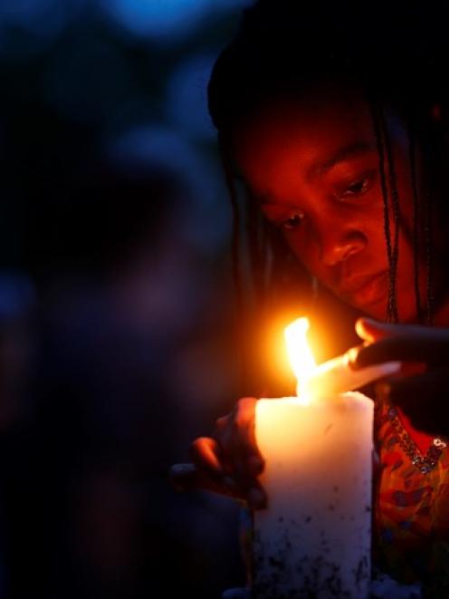 A girl lights candles outside the house where Nelson Mandela died in Johannesburg as South...