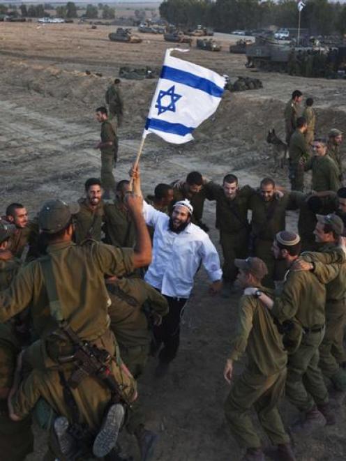 A Hasidic Jew  waves an Israeli flag as he dances with Israeli troops yesterday during a visit to...