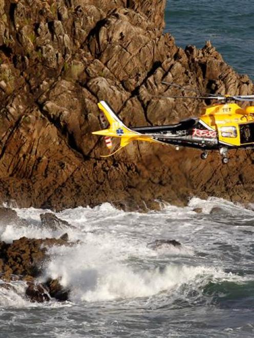 A helicopter conducts a search for two missing high school pupils and their instructor  off New...