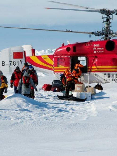 A helicopter from the Xue Long (Snow Dragon) Chinese icebreaker unloads rescued passengers from...
