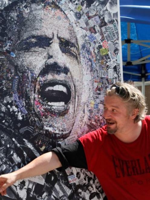 A local artist named 'O' shows off his lithograph featuring President Barack Obama for sale at...