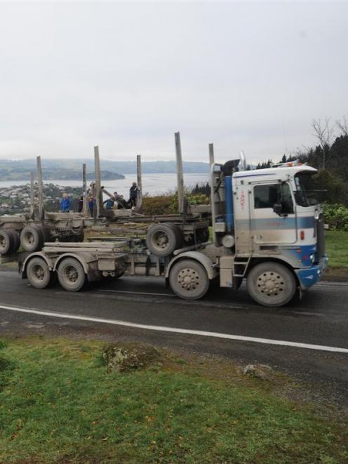 A logging truck negotiating Blueskin Rd squeezes around a tight corner at the Scott Monument,...