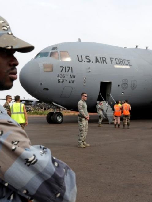 A Malian gendarme stands guard after the arrival of a US Air Force C-17 transport plane with...