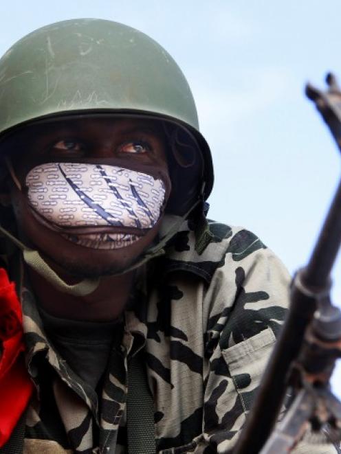 A Malian soldier stands guard with his machine gun on the road between Konna and Sevare. REUTERS...