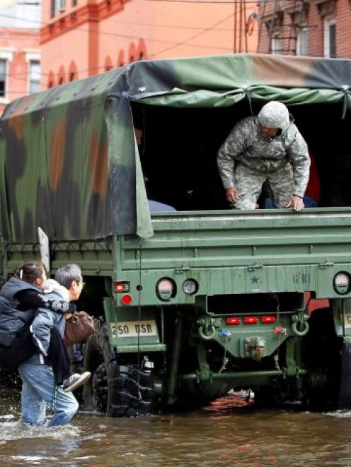 A man carries his wife through the floodwaters to a National Guard truck in Hoboken, New Jersey....