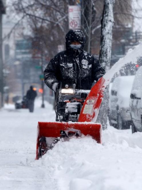 A man clears snow with a snow blower in the South Bronx section of New York City. REUTERS/Mike Segar