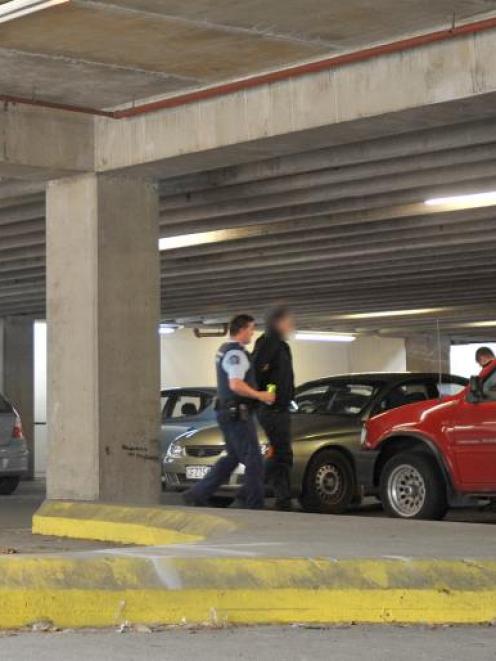 A man is taken into custody by police in a car park near central Dunedin's Work and Income New...