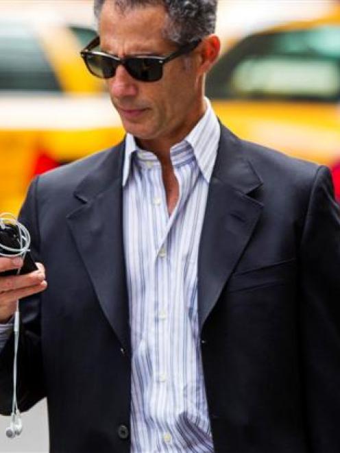 A man uses his Apple iPhone while walking down 5th Avenue in New York. REUTERS/Lucas Jackson