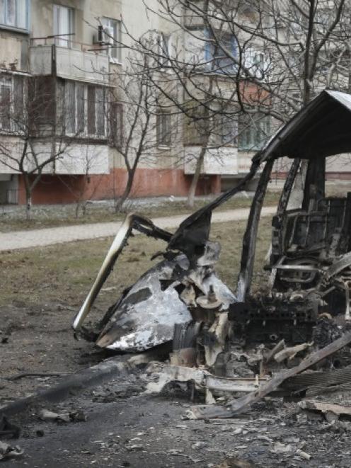 A man walks past a burnt-out vehicle after a shelling by pro-Russian rebels of a residential...