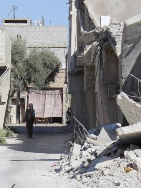 A man walks past damaged buildings in Duma neighbourhood of Damascus, Syria. REUTERS/Bassam Khabieh