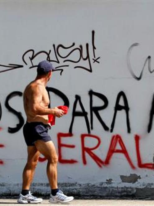 A man walks past graffiti against Portugal's Prime Minister Pedro Passos Coelho on the streets of...