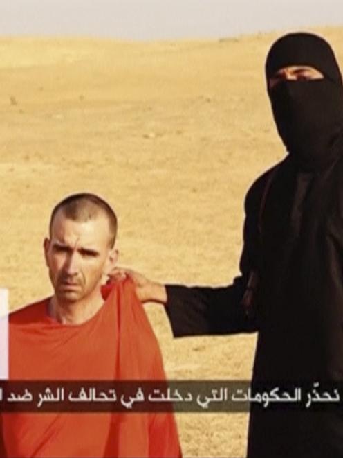 A masked, black-clad militant, who has been identified by the Washington Post newspaper as a...