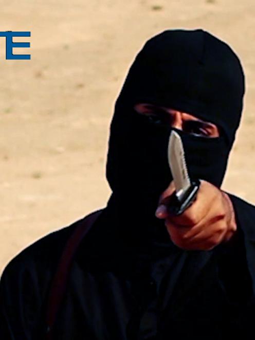 A masked, black-clad militant, who has been identified by the Washington Post newspaper as a...