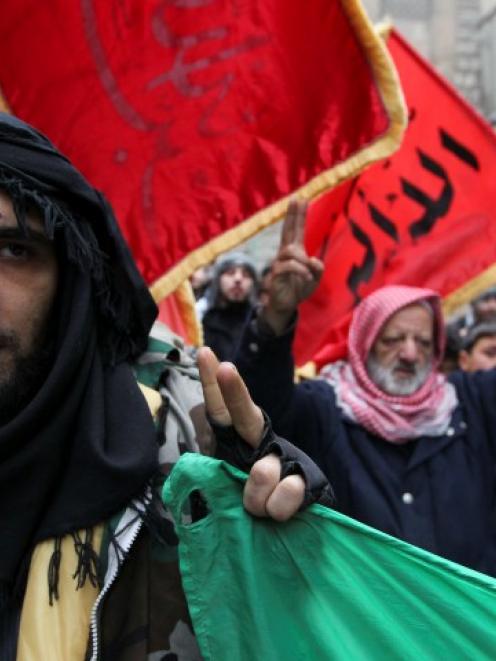 A member of the Free Syrian Army flashes the victory sign during a protest against Syria's...