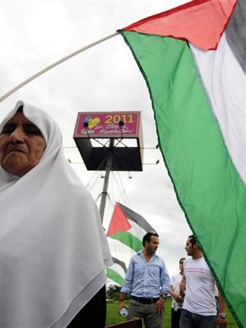 A member of the Palestinian community holds a Palestinian flag near the office of the United...
