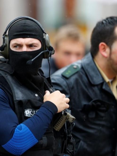 A member of the special police force (L) walks beside a policeman along a street in Ingolstadt...