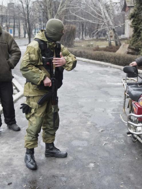 A member of the Ukrainian armed forces offers local residents a chance to join people who are...