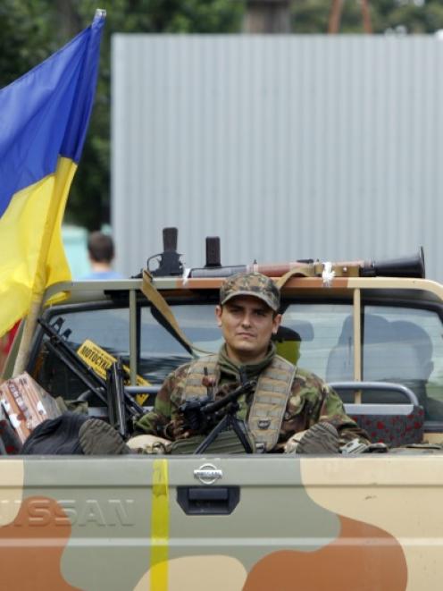 A member of Ukrainian self-defence battalion "Donbass" rides on a pick-up truck during a patrol....