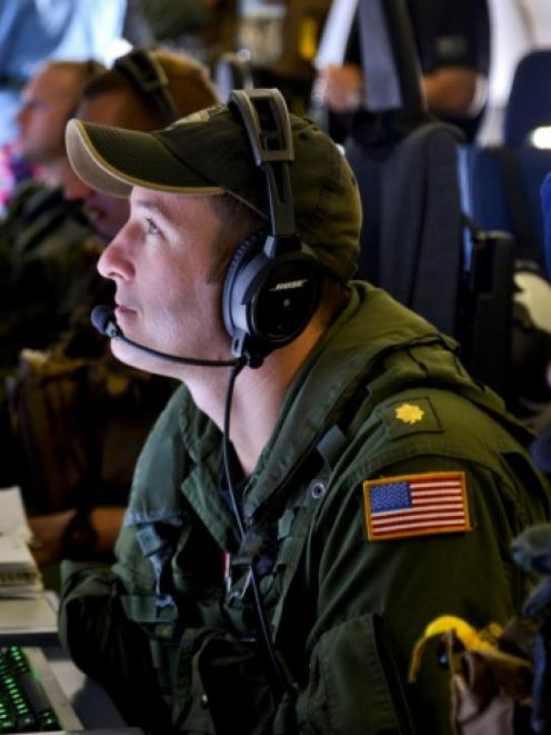 A Naval Flight Officer assigned to Patrol Squadron (VP) 16, monitors his workstation on a P-8A...