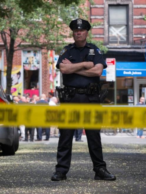 A New York Police Officer stands guard inside a cordoned area at the site of a shooting in...