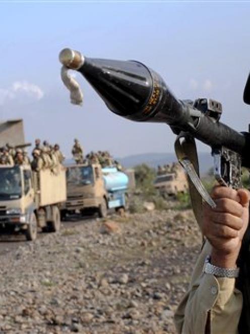 A Pakistani paramilitary soldier secures an area as other troops move toward a forward base...
