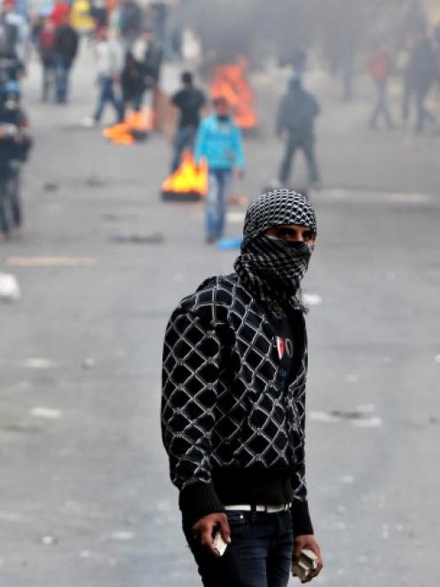 A Palestinian protester holds stones during clashes with Israeli soldiers in the West Bank city...