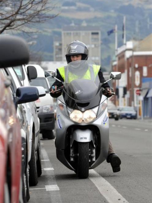A parking officer on patrol in Dunedin. The city council yesterday backed away from its parking...