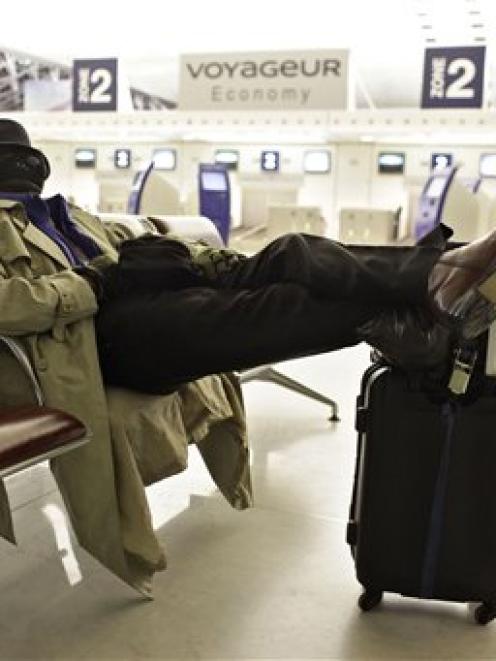 A passenger rests at Roissy Charles de Gaulle Airport, as hundreds of commercial flights across...