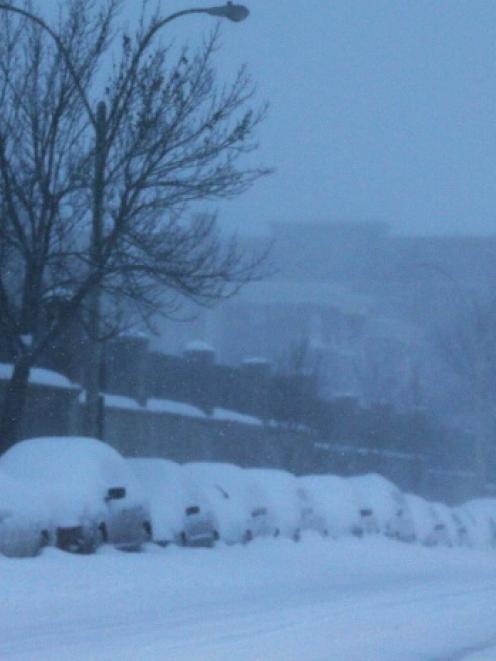 A pedestrian walks along a snow covered road during a blizzard in Somerville, Massachusetts....