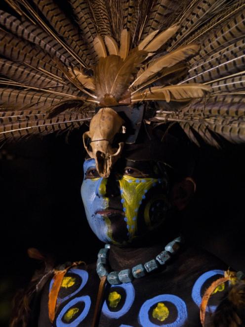 A performer wears a traditional costume as he takes part in the opening ceremony of the Mayan...
