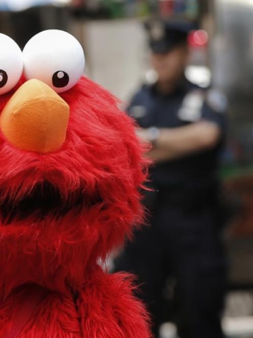 A person dressed as the Sesame Street character Elmo walks through Times Square in New York....